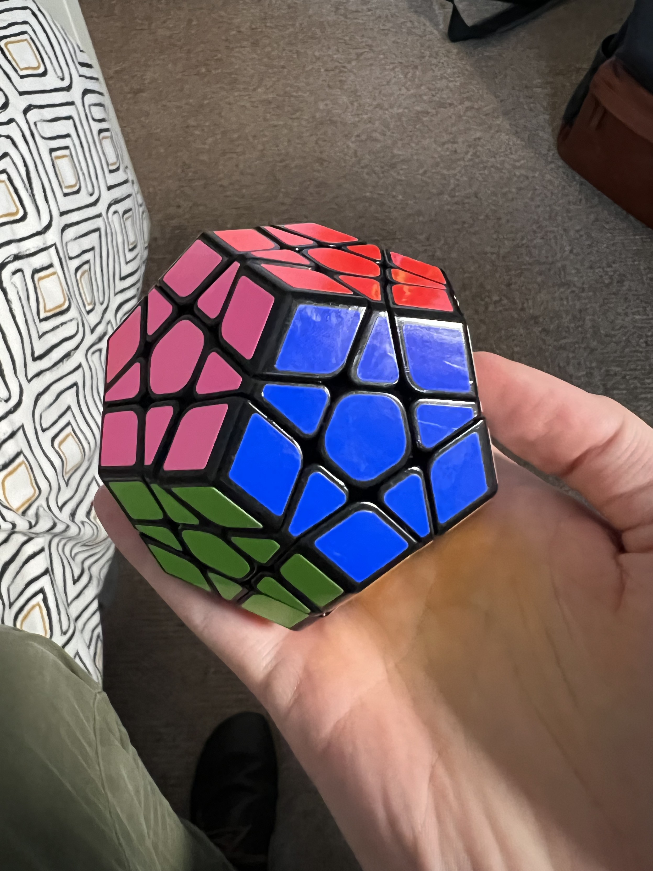 My hand holding a solved megaminx puzzle